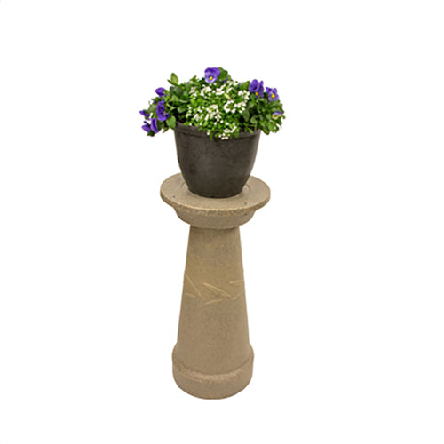 Chapeau décoratif pour évent de système septique avec une plante déposée sur le dessus.