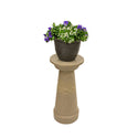 Chapeau décoratif pour évent de système septique avec une plante déposée sur le dessus.